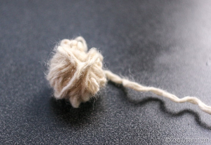 Al enrollar más lana, la bola de lana empieza a formar una esfera.