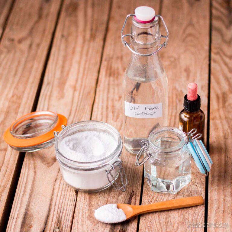 Ingredientes para suavizante natural de ropa: vinagre, bicarbonato, glicerina y aceite esencial sobre mesa de madera