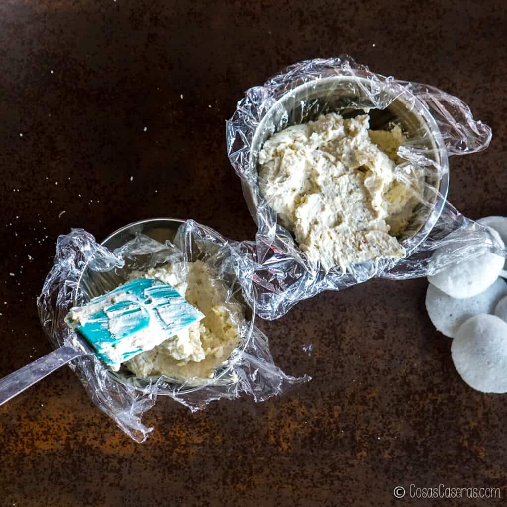 Colocando la mezcla de crema de queso en boles forrados con plástico