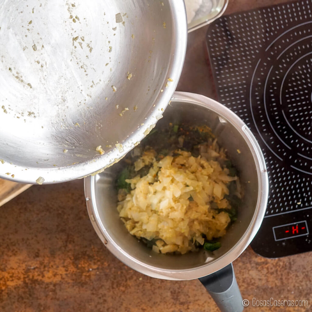 Echando las cebolla cocinadas al procesador de alimentos con las espinacas cocidas