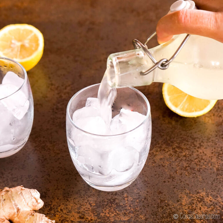 Vertiendo ginger beer casero en un vaso con hielo