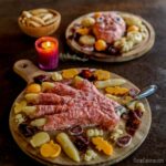 Dos tablas de queso de Halloween. Una en forma de una mano y otra en forma de una cara.