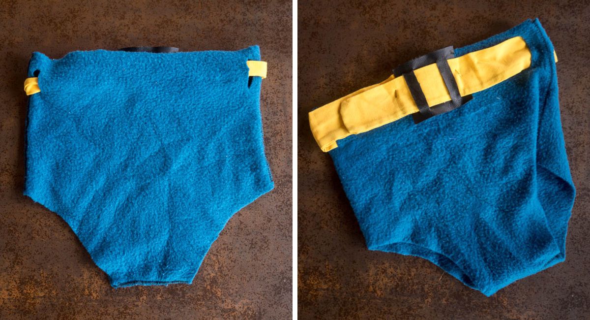 Vistas delantera y trasera de unos calzoncillos de Batman hechos con tela polar azul y un cinturón amarillo con hebilla negra.