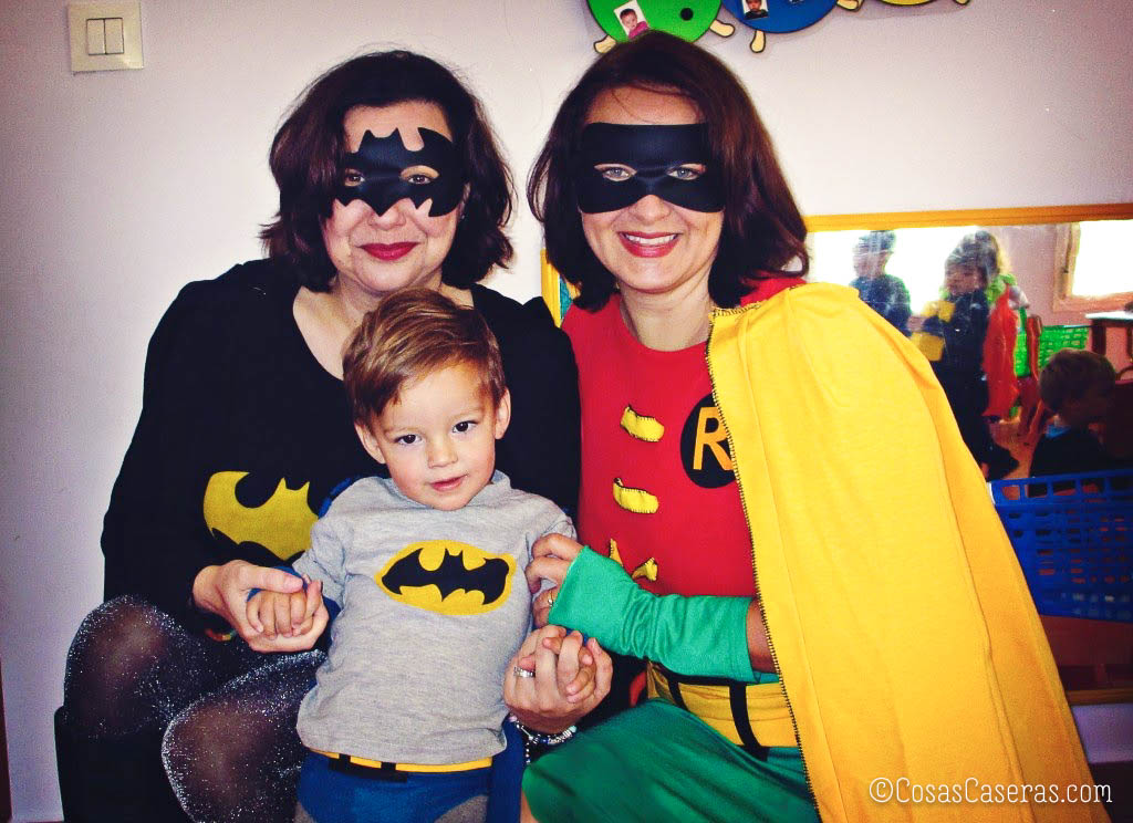 Dos mujeres y un niño pequeño vestidos con disfraces de Batman y Robin.